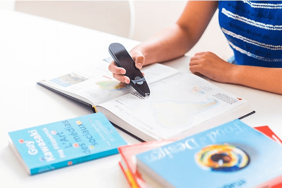 A business professional digitizing printed text into a laptop using a wireless pen scanner