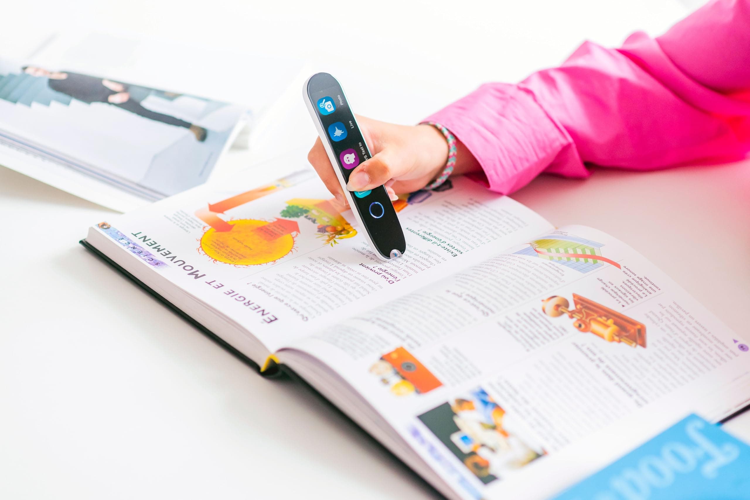 Top assistive reading pen scanner on an open textbook for reading review
